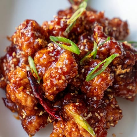 Crispy General Tsos Chicken tossed with dried chilies and sesame seeds, creating a sweet and tangy Chinese-American takeout favorite.
