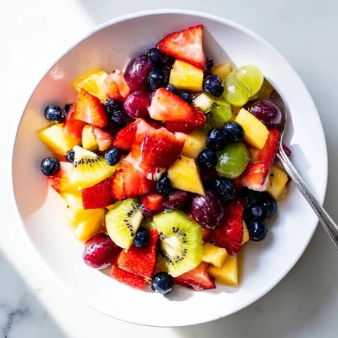 Fresh, colorful Fruit Salad features juicy strawberries, pineapple, and grapes tossed in a shiny citrus syrup.