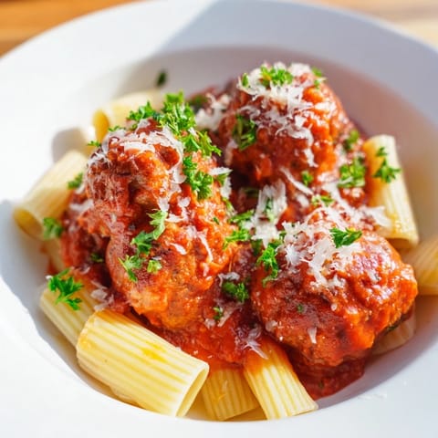 Savory oven-baked turkey meatballs in rich tomato sauce, twirled onto a fork with al dente spaghetti and fresh parsley.