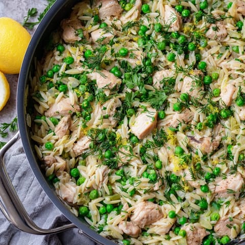 Bright, zesty Lemon Herb Chicken Orzo Skillet with tender golden chicken, fresh dill, and bright green peas served in the pan.