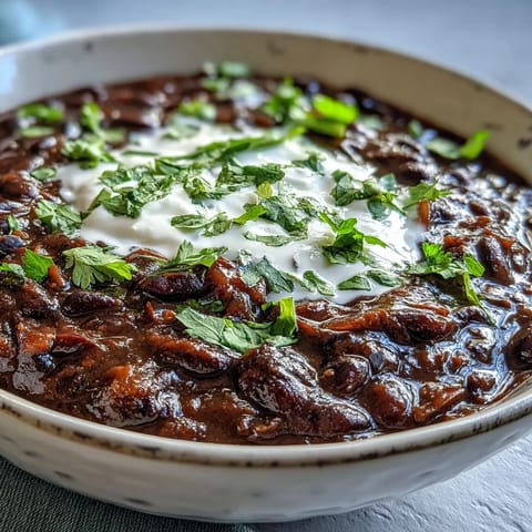 Creamy black bean soup simmered with warming spices, served hot with lime wedges on the side.
