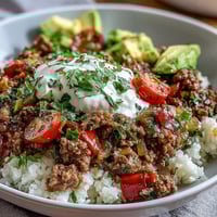 Freshly seasoned ground beef and fluffy cauliflower rice layered in a Low Carb Burrito Bowl with crisp romaine.