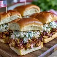 1. Juicy BBQ chicken sliders topped with tangy coleslaw on soft slider buns, perfect for 4th of July celebrations.