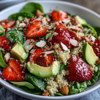 Fresh strawberry avocado quinoa salad with creamy avocado, juicy berries, and citrus dressing in a bright bowl.  